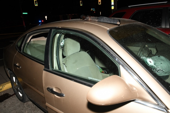 Figure 2 - The 2005 Buick Allure 4-door.  A bullet hole is visible to the front windshield and passenger window.  The sawed-off shotgun is on top of the vehicle.