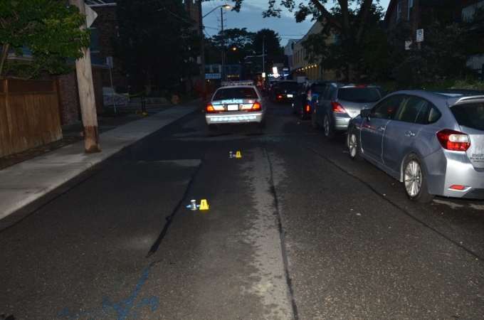 A northbound view of WO #2 and WO #3’s police cruiser on Bowden Street. Two nickel cartridge cases, indicated by yellow evidence markers, were located just south of the cruiser.