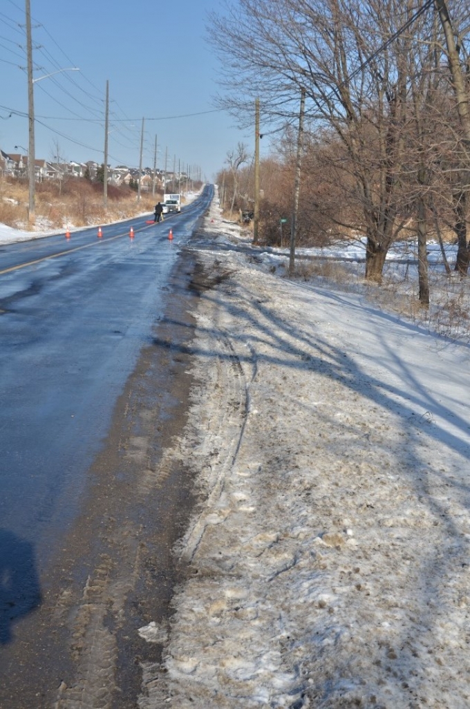 Les traces de pneus dans la neige du côté droit de Townline Road, là où le conducteur a commencé à perdre la maîtrise de son véhicule Kia et a quitté la chaussée revêtue.