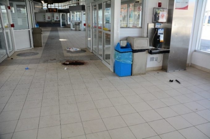 L’un des couteaux du plaignant se trouve par terre, du côté droit de la photo. La flaque de sang marque l’emplacement où le plaignant est tombé après avoir reçu une balle. (La porte d’entrée est du côté droit de la photo, tandis que le poste de sécurité est à gauche.)