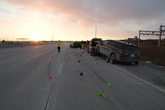 The undamaged tow truck and vehicle that were also on the scene. The yellow evidence marker "1" in the foreground indicates the first gouge in the concrete and is the best indication of the area of impact for the collision.