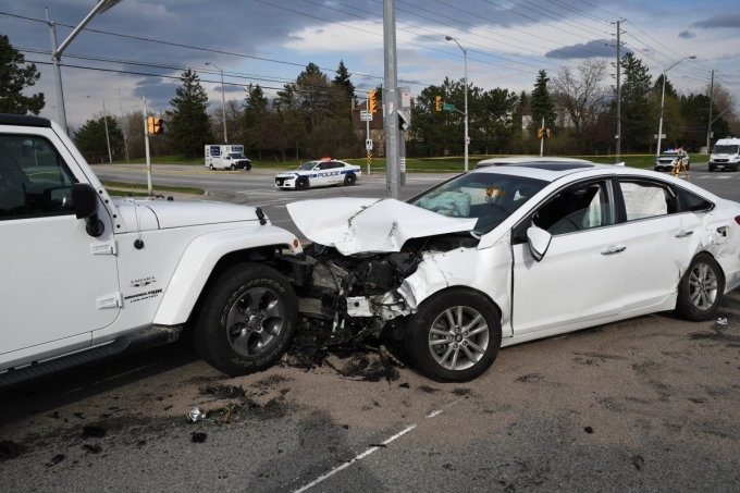 This photograph faces southeast from the centre of Dixie Road depicting the front and left side of the Hyundai Sonata. The damage to the front is evident and the damage to the left rear fender and door indicates the secondary area of impact. The front is visibly in contact with a Jeep Wrangler.