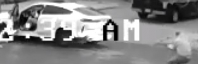 Figure 18 - Saisie d&rsquo;&eacute;cran de la vid&eacute;o - l&rsquo;AT n&deg; 1 pointe une arme &agrave; feu vers la BMW.