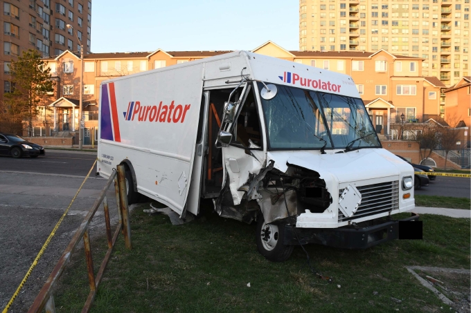 Figure 1 - Une camionnette Purolator cubique avec des dommages apparents près de la portière droite est immobilisée sur le côté ouest de Brimley Road.